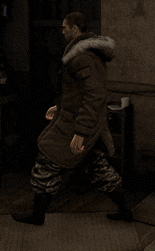 a man in a parka with a fur hood is walking