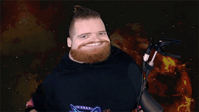 a man with a beard is standing in front of a microphone with a galaxy in the background .
