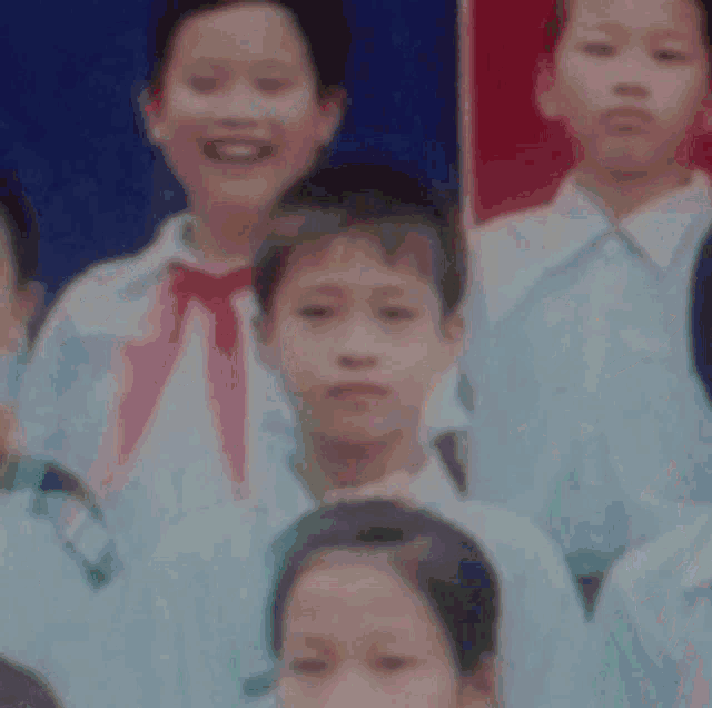 a young boy is making a funny face while sitting in a room with other people .