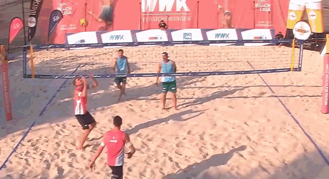 a beach volleyball game is being played in front of a wwk sign