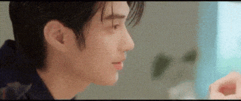 a close up of a person 's face with a blurry background and a person 's hand in the foreground .