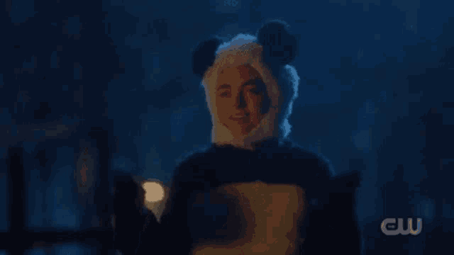a person wearing a panda costume with their eyes closed and a panda hat .