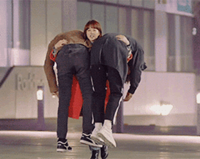 a man is carrying a woman on his back in front of a building that says ' park ' on it
