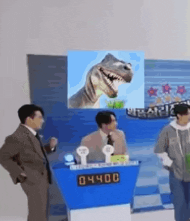 a man in a suit and tie is standing in front of a podium with a dinosaur on it .