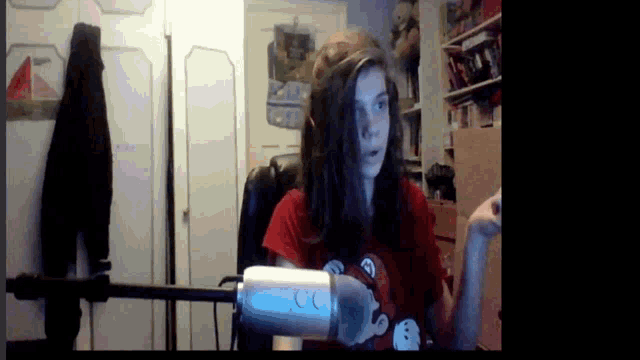 a woman in a red shirt is holding a white microphone