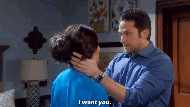 a man in a blue shirt is touching a woman 's neck and says " i want you "