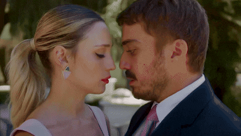 a man in a suit and tie kisses a woman