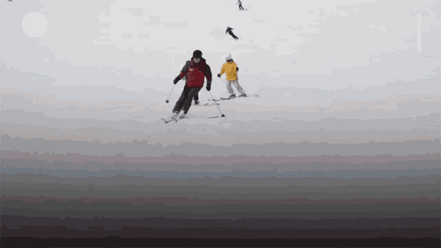 a man in a red jacket is skiing down a snow covered hill