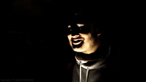 a man in a black hoodie is smiling in the dark with the words reload yt / deydirmen below him