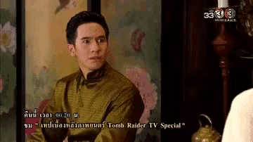 a man is sitting in front of a tv screen that says tomb raider