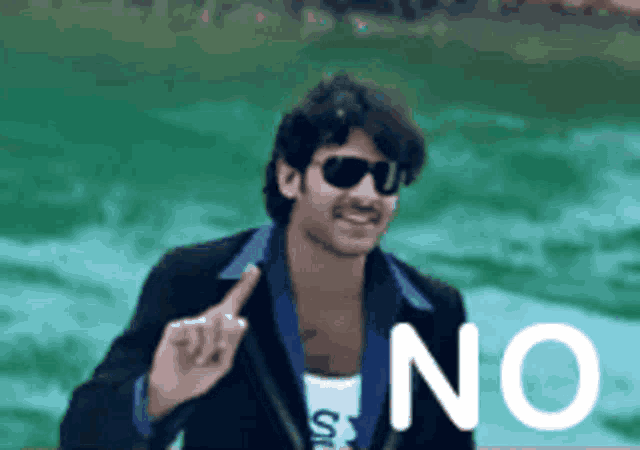 a man wearing sunglasses is pointing at the word no in front of him