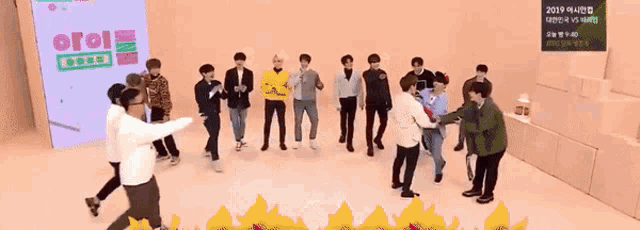 a group of men are dancing in front of a sign that says ' 2019 '