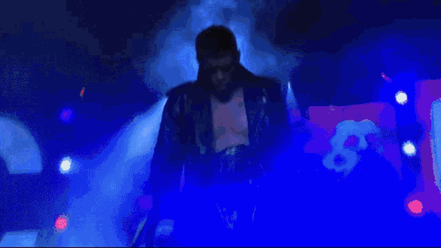 a man in a leather jacket is walking down stairs in front of a sign that says r.