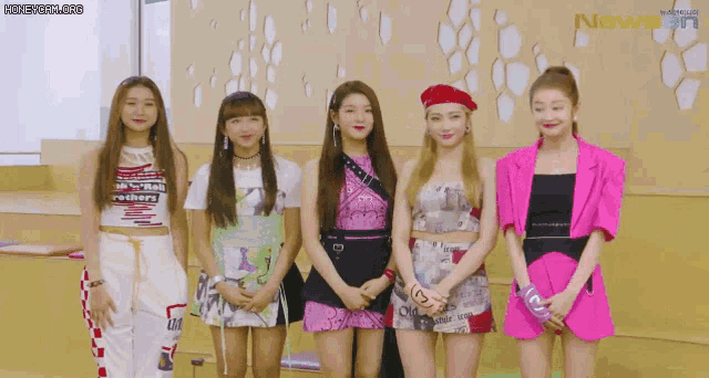 a group of girls standing next to each other with a newsen logo in the corner