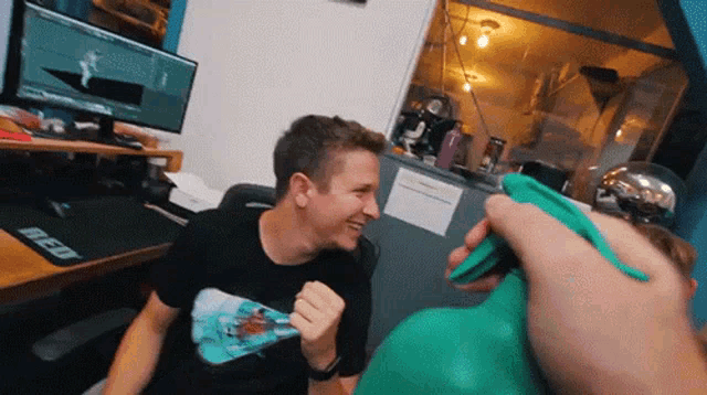 a man wearing a black shirt with the word red on it is laughing