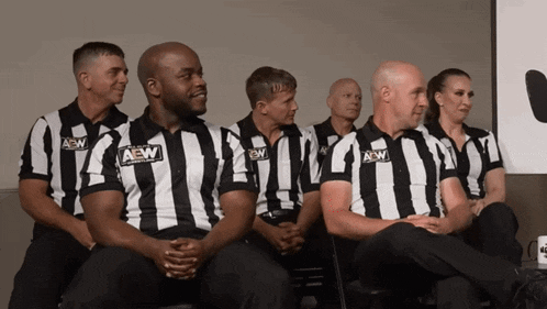 a group of aew referees sit in a line
