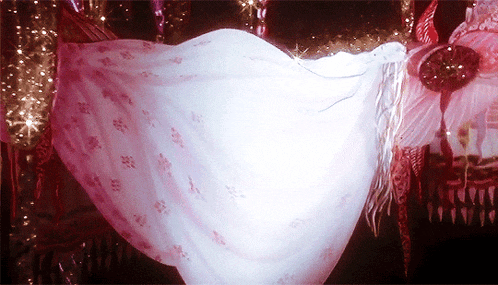 a woman in a long white dress is dancing in the dark