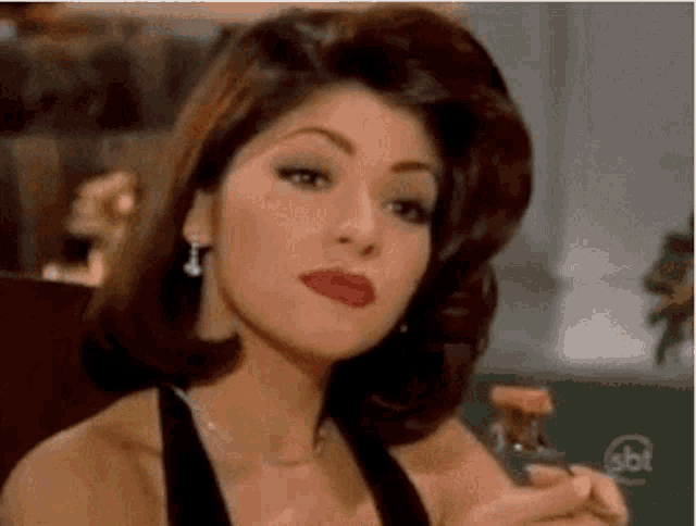a woman is sitting at a table holding a glass of wine .