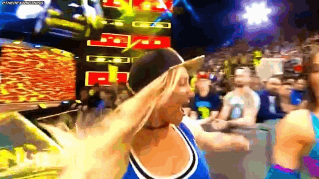 a woman wearing a hat is standing in front of a crowd with a watermark that says there is nothing