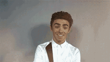 a man in a white shirt and tie is smiling .