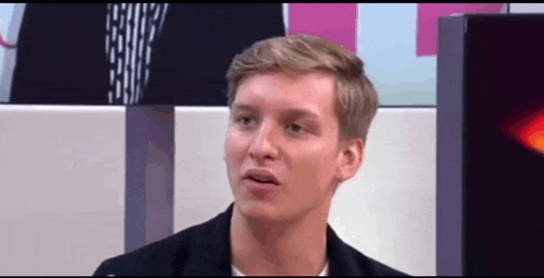 a man in a black jacket looks at the camera
