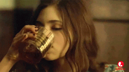 a woman is drinking from a glass with a lifetime logo in the background