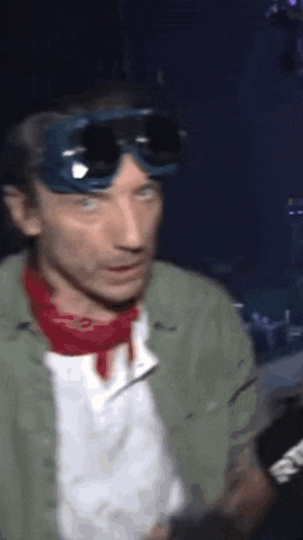 a man wearing goggles and a red bandana looks at something