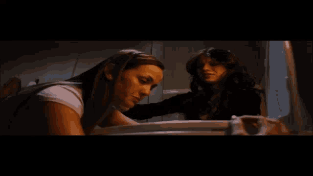 two women are looking into a toilet seat