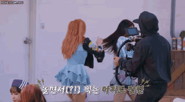 a group of girls are dancing in front of a camera with the words honeycam.org written on the bottom