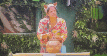 a woman wearing a reindeer headband is holding a bowl of food