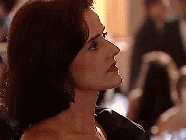 a close up of a woman 's face in a black dress