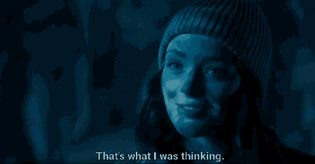 a woman wearing a blue beanie is smiling and says that 's what i was thinking