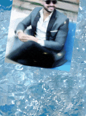 a man in a suit and sunglasses is floating in a pool