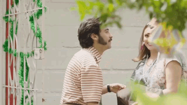 a man kissing a woman on the cheek in front of a sign that says tv