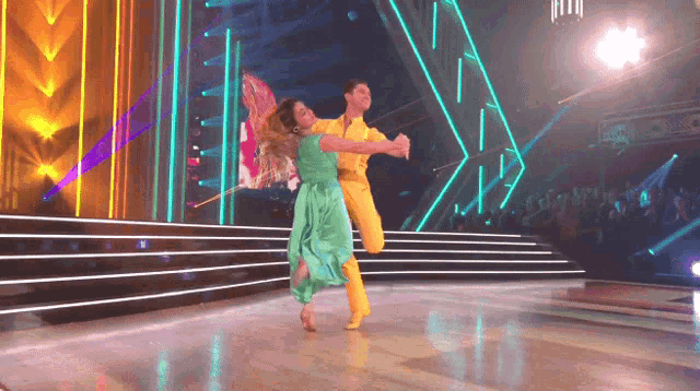 a man and a woman are dancing on a stage