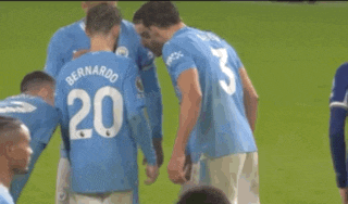a soccer player with the number 20 on his back is surrounded by other players