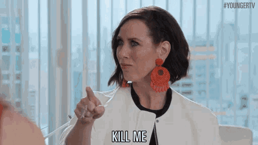 a woman in a white jacket and earrings is pointing at another woman and saying `` kill me '' .