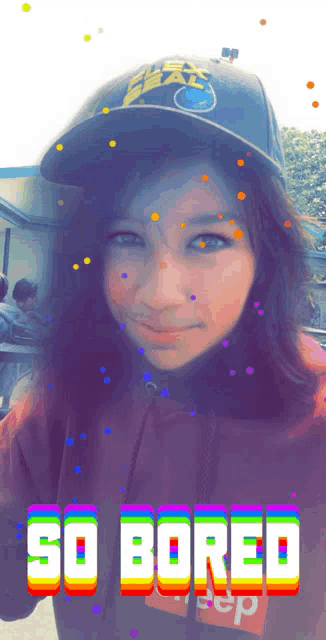 a girl wearing a hat and a hoodie with the words so bored written on it