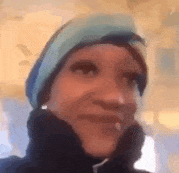 a woman wearing a blue hat and a black jacket is smiling .