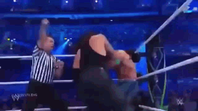 two wrestlers are fighting in a wrestling ring with a tnt logo in the background