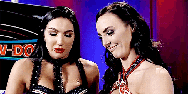 two women are standing next to each other in front of a sign that says " v-do "