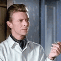 a man in a white shirt and tie is holding a glass of water in his hand .