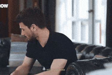 a man in a black shirt is sitting on a couch with the words minimalmoons written on the bottom