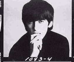 a black and white photo of a young man with his hand to his chin .