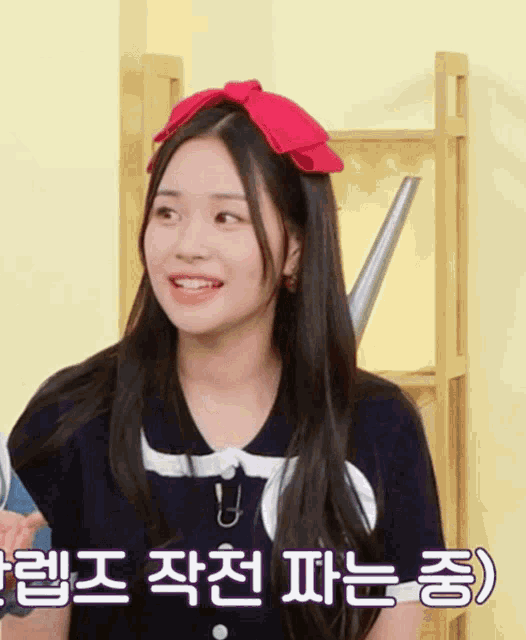 a girl wearing a red headband with korean writing on it smiles