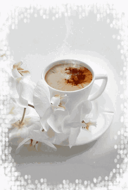 a cup of coffee on a saucer with white flowers