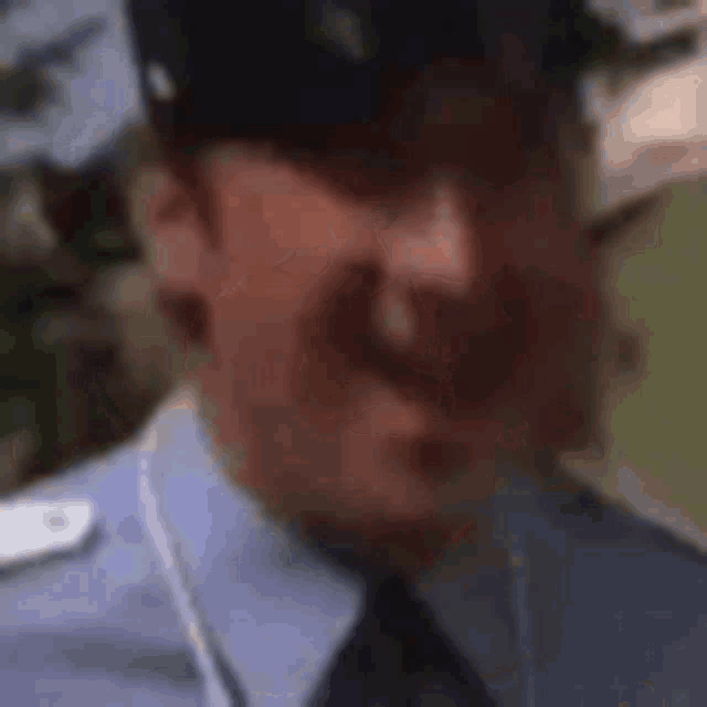 a man in a blue shirt and black tie is laughing .