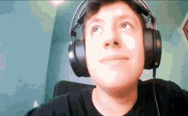 a man wearing headphones looks up at the camera