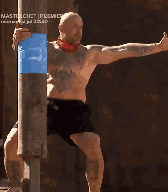 a man without a shirt is standing in front of a sign that says master chef premiera