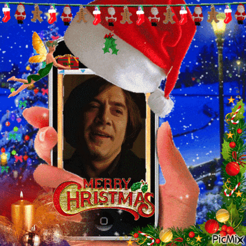 a person holding a cell phone with a picture of a man and the words merry christmas on it